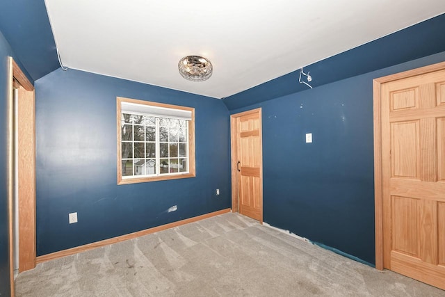 unfurnished bedroom with carpet and vaulted ceiling