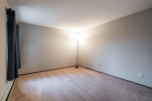 carpeted spare room featuring baseboard heating