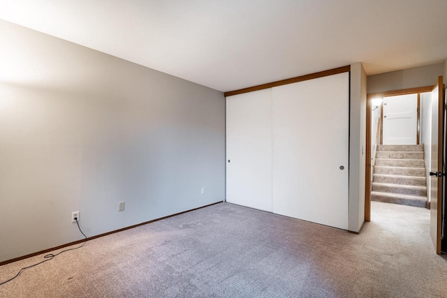 unfurnished bedroom featuring carpet flooring and a closet