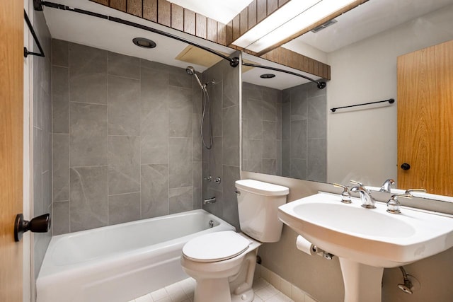 full bathroom featuring tile patterned floors, tiled shower / bath combo, toilet, and sink