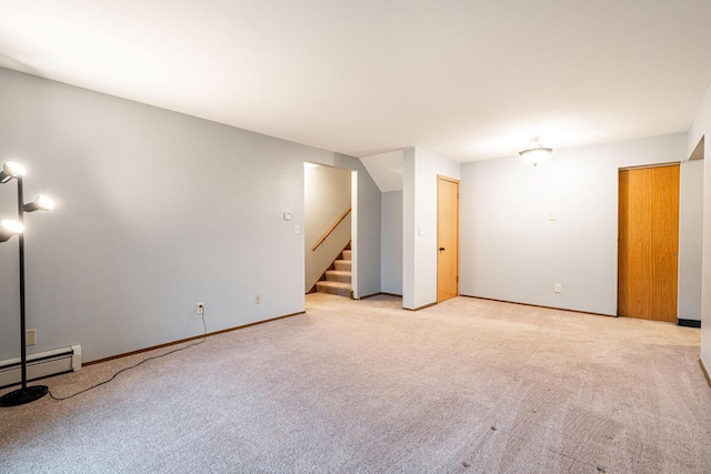 carpeted spare room featuring a baseboard heating unit