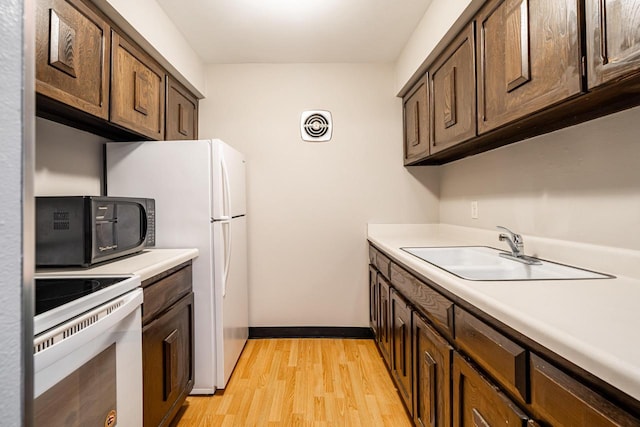 kitchen featuring dark brown cabinetry, sink, light hardwood / wood-style floors, and white electric range