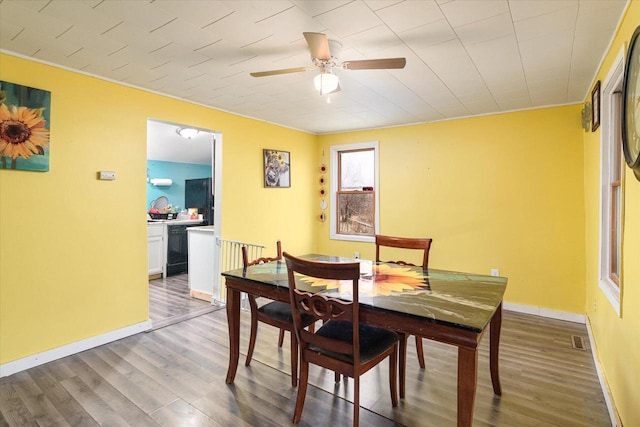 dining space with hardwood / wood-style floors, ceiling fan, and ornamental molding