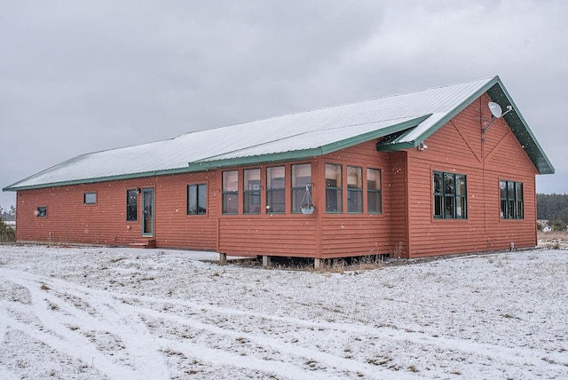 view of snow covered back of property