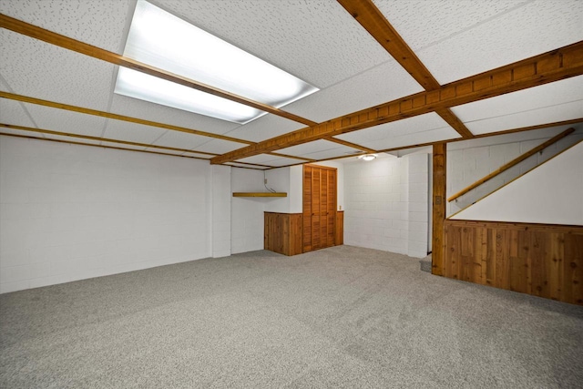 basement featuring wooden walls and carpet