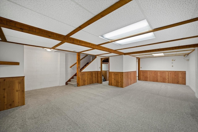 basement with carpet flooring and wood walls