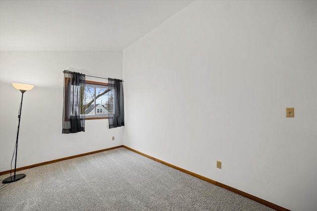 spare room featuring carpet flooring and lofted ceiling