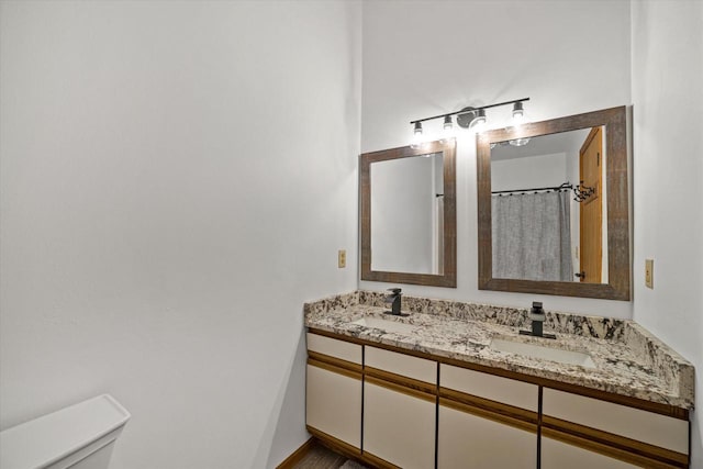 bathroom featuring vanity, toilet, and walk in shower