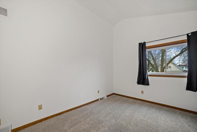 carpeted spare room featuring lofted ceiling