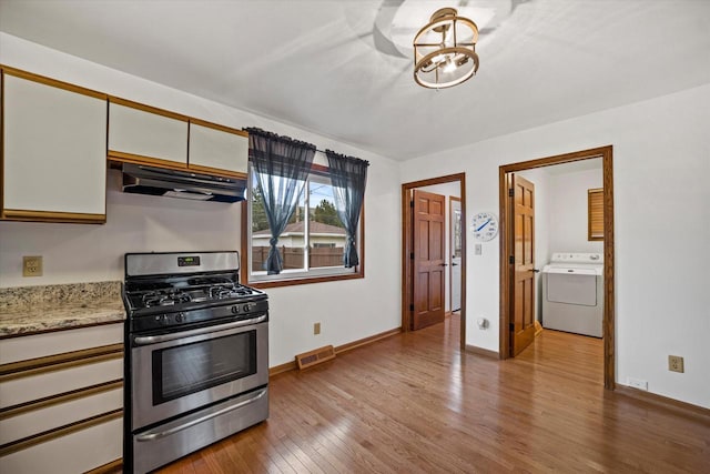 kitchen with white cabinets, stainless steel gas stove, washer / clothes dryer, and light hardwood / wood-style flooring