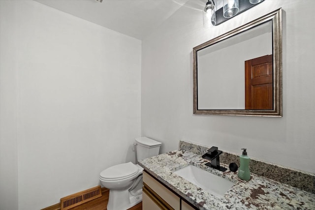 bathroom featuring hardwood / wood-style flooring, vanity, and toilet