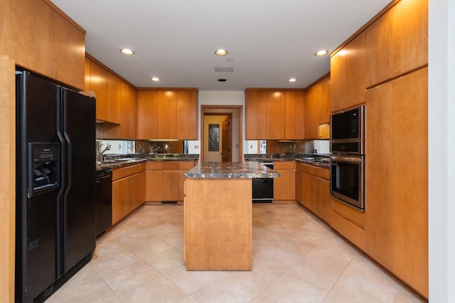 kitchen featuring black appliances, a kitchen island, and light tile patterned floors