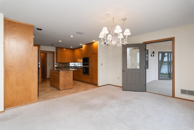 kitchen featuring hanging light fixtures, a notable chandelier, black double oven, light colored carpet, and a kitchen island