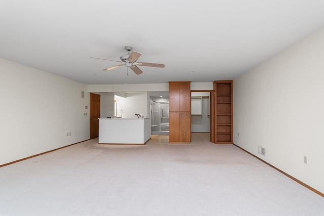 unfurnished living room featuring ceiling fan and light colored carpet