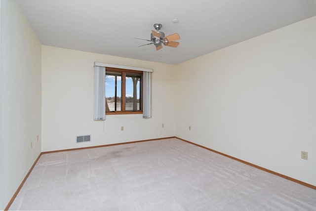 carpeted spare room featuring ceiling fan