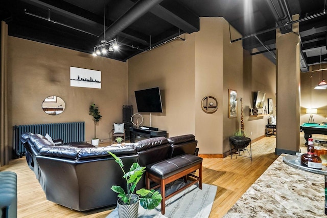 living room with hardwood / wood-style floors and a towering ceiling