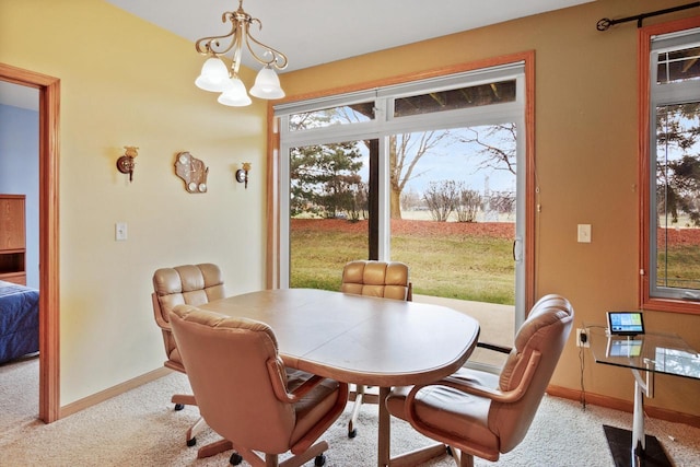 dining space with light colored carpet and a notable chandelier