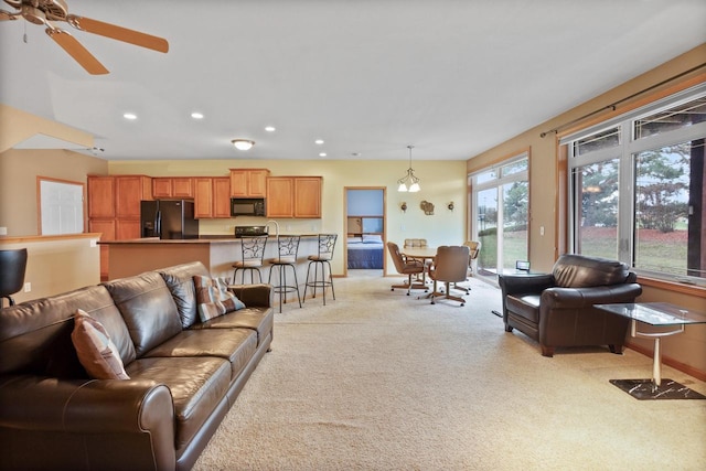 carpeted living room featuring ceiling fan