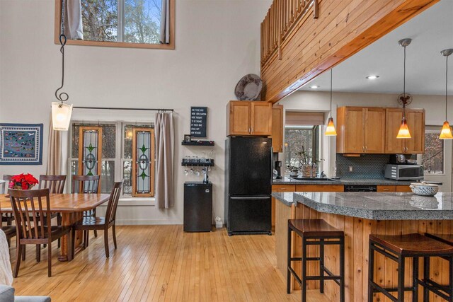458 Pro Trl, Nekoosa, WI 54457 - kitchen with black appliances, a kitchen breakfast bar, plenty of natural light, tile countertops, and a towering ceiling