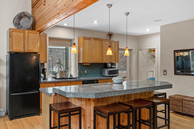 458 Pro Trl, Nekoosa, WI 54457 - kitchen with black appliances, tile counters, light wood-type flooring, a breakfast bar, and recessed lighting
