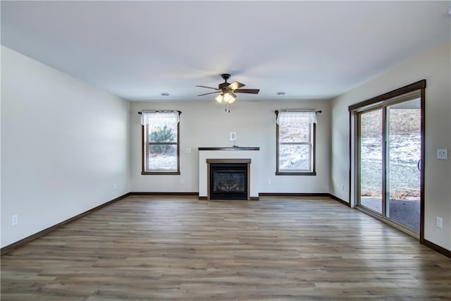 unfurnished living room featuring ceiling fan and hardwood / wood-style flooring