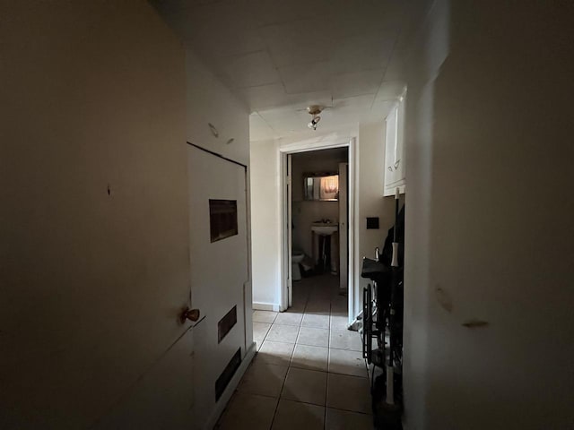 hall with sink and light tile patterned flooring