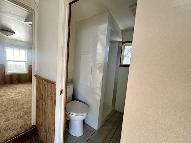 bathroom with wooden walls and toilet