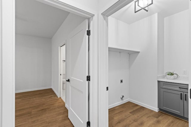 clothes washing area with hookup for an electric dryer and light hardwood / wood-style flooring