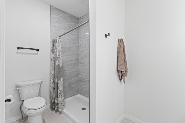 bathroom featuring tile patterned flooring, a shower with shower curtain, and toilet