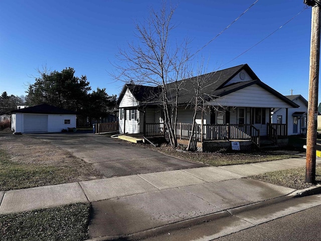 view of front of house with a porch, a garage, and an outbuilding