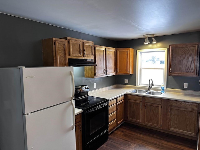 kitchen featuring black range with electric cooktop, white fridge, dark wood-type flooring, and sink