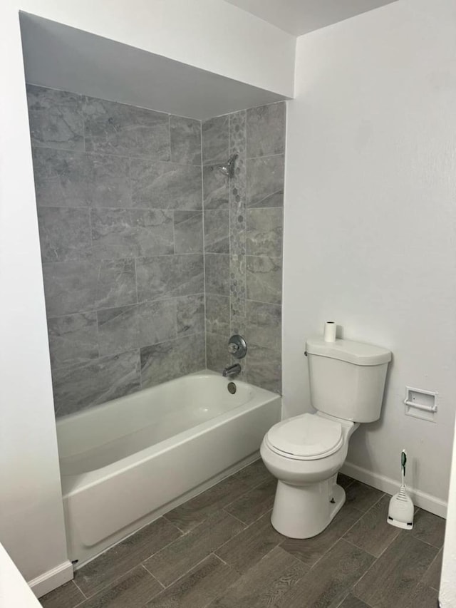 bathroom featuring tiled shower / bath and toilet