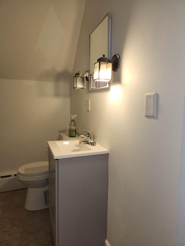 bathroom featuring vanity, a baseboard heating unit, tile patterned floors, vaulted ceiling, and toilet