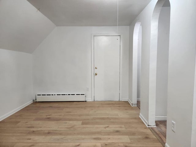 bonus room featuring light hardwood / wood-style flooring, vaulted ceiling, and a baseboard heating unit