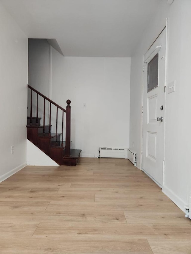 unfurnished room featuring light hardwood / wood-style floors and baseboard heating