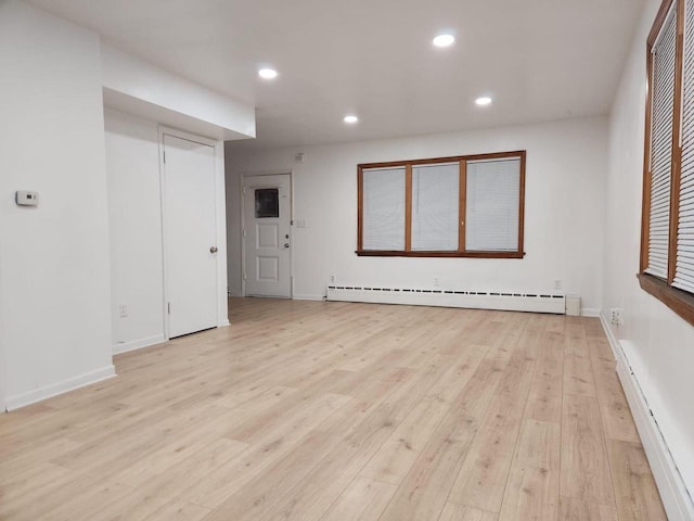 spare room with a baseboard radiator and light wood-type flooring