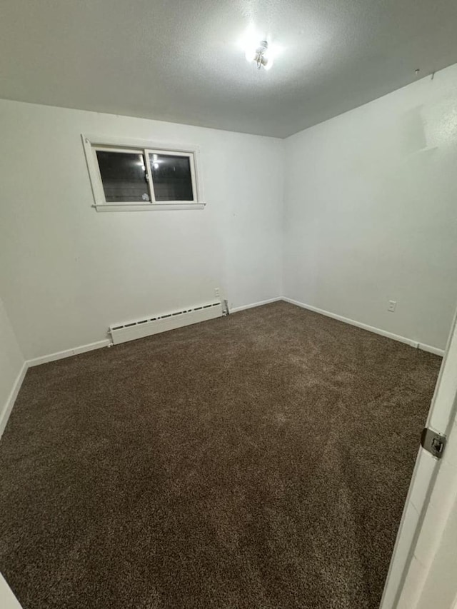 spare room with a textured ceiling, carpet floors, and baseboard heating