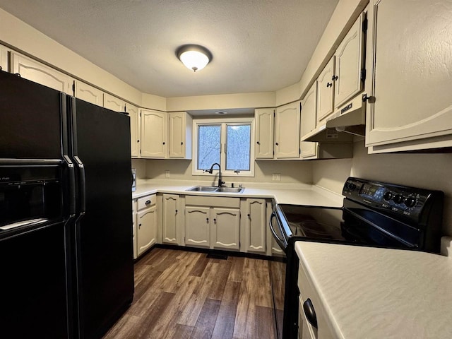 kitchen featuring dark wood-type flooring, black appliances, sink, a textured ceiling, and white cabinetry