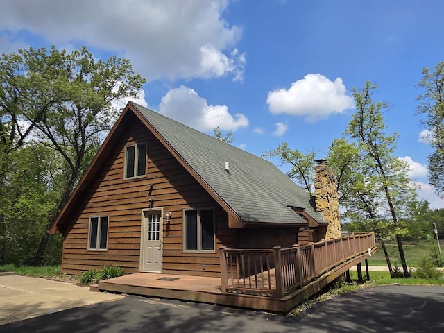 7409 Timberline Trl, Arena, WI 53503 - view of front of house featuring a wooden deck, a chimney, and a shingled roof