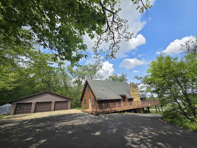 7409 Timberline Trl, Arena, WI 53503 - view of front of property with a wooden deck, an outdoor structure, a detached garage, and a chimney