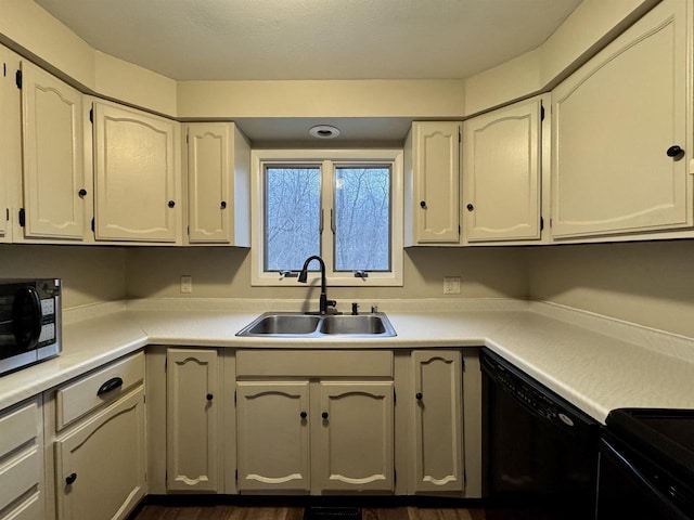 kitchen with white cabinets, black dishwasher, and sink