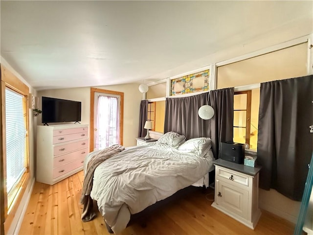 bedroom featuring light hardwood / wood-style flooring and vaulted ceiling