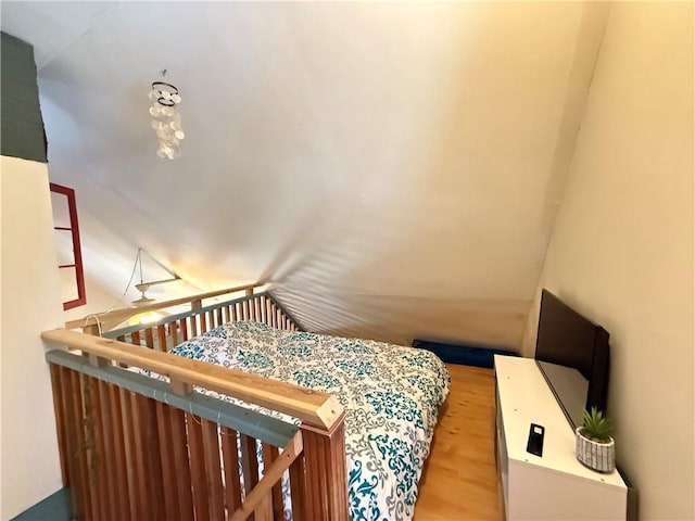 bedroom with vaulted ceiling and hardwood / wood-style flooring