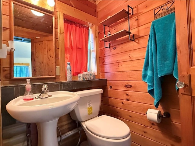 bathroom with toilet and wooden walls