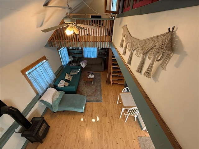 living room with light hardwood / wood-style floors, ceiling fan, and lofted ceiling