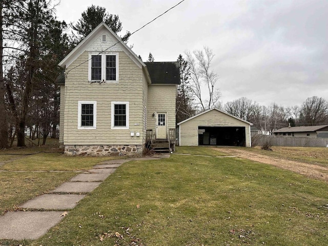 view of front of home featuring a front lawn, an outdoor structure, and a garage