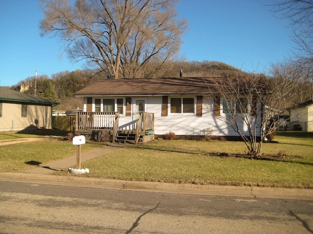 ranch-style home with a front yard and a deck