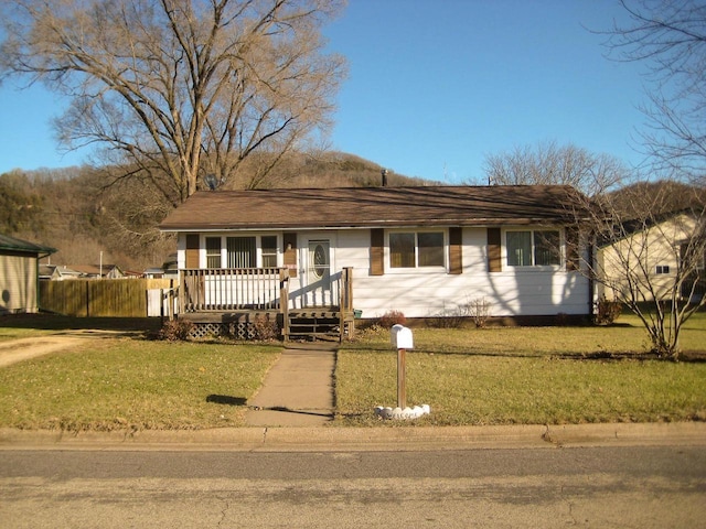 ranch-style house featuring a front lawn and a deck