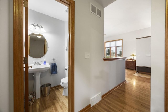 hall with light hardwood / wood-style floors and sink