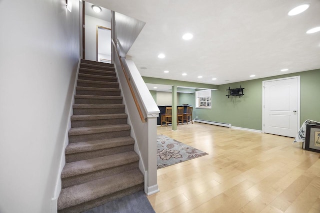 stairway featuring hardwood / wood-style floors and a baseboard radiator